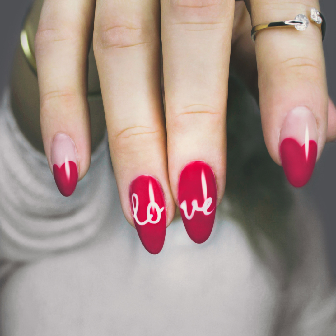 Red French Tip Manicure with "lo" on the ring finger nail and "ve" on the middle finger nail